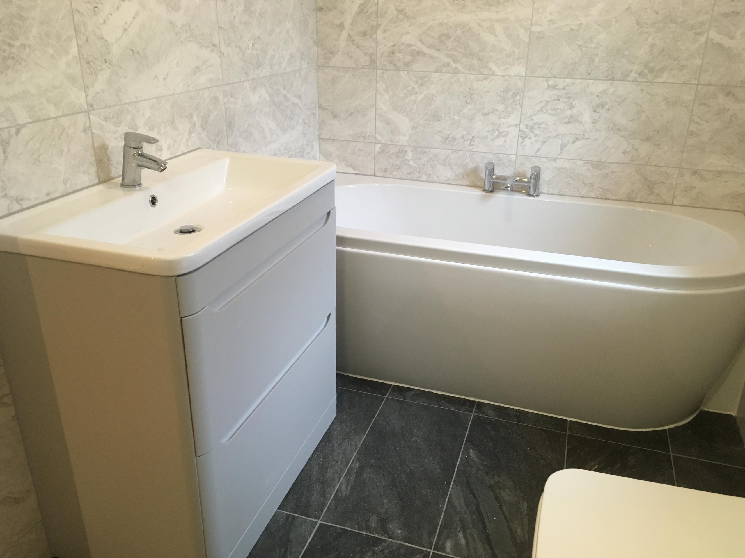 Full installation of double ended bath and basin upon unit