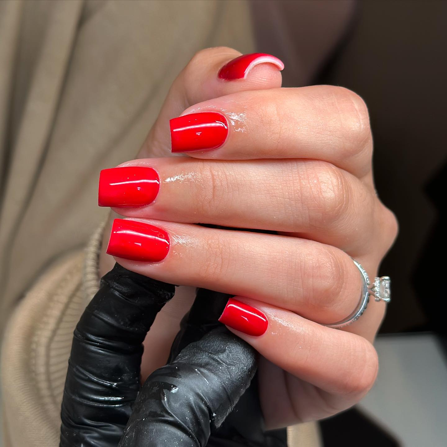 The Glam Angel - A picture of a hand with freshly painted red nails
