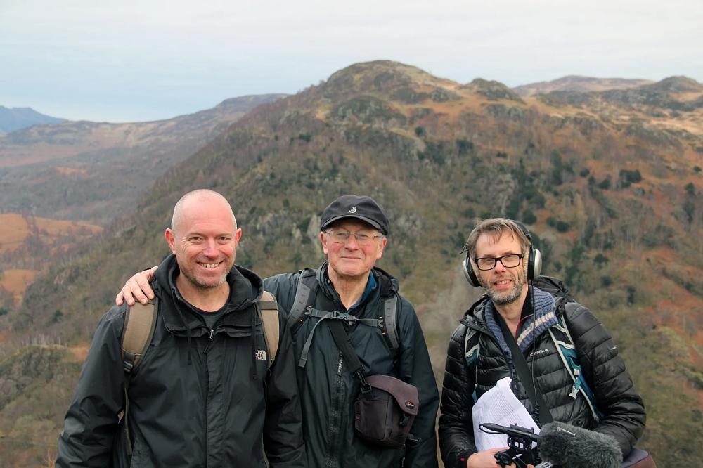 Countrystride podcast group stood on top of Castle Crag with mountains in the background