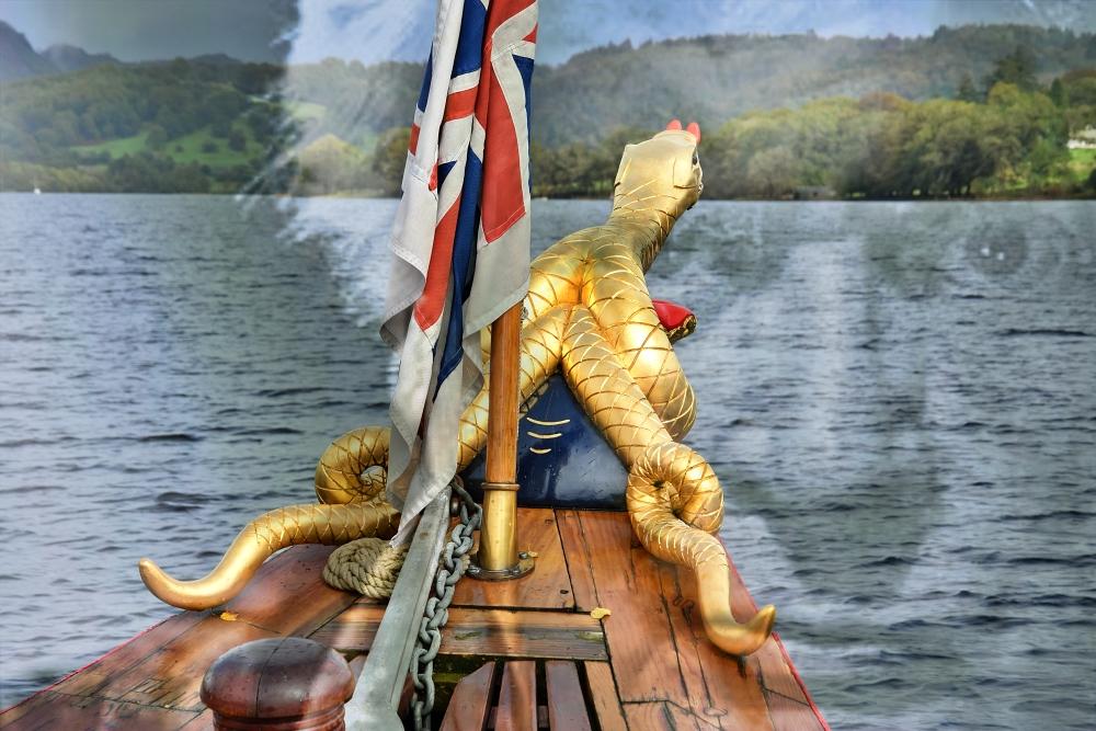 The bow of the gondola on Coniston with a overlaid, transparent image of Ken Russell