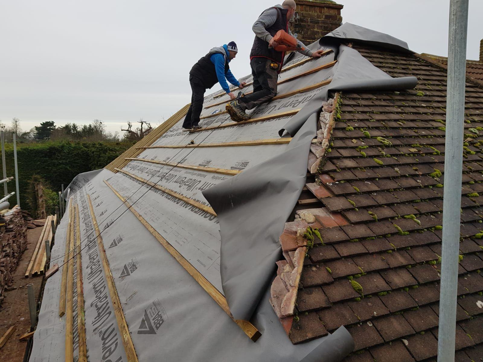 two men working to repair a roof