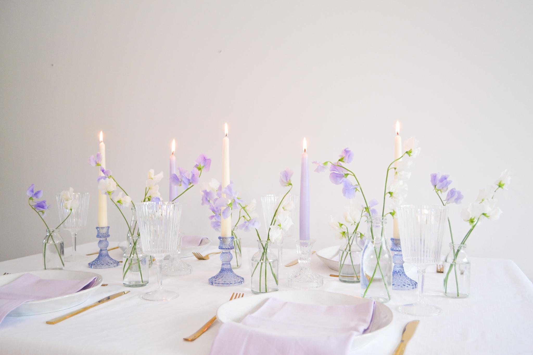 Lilac and white sweet peas with tapered candles