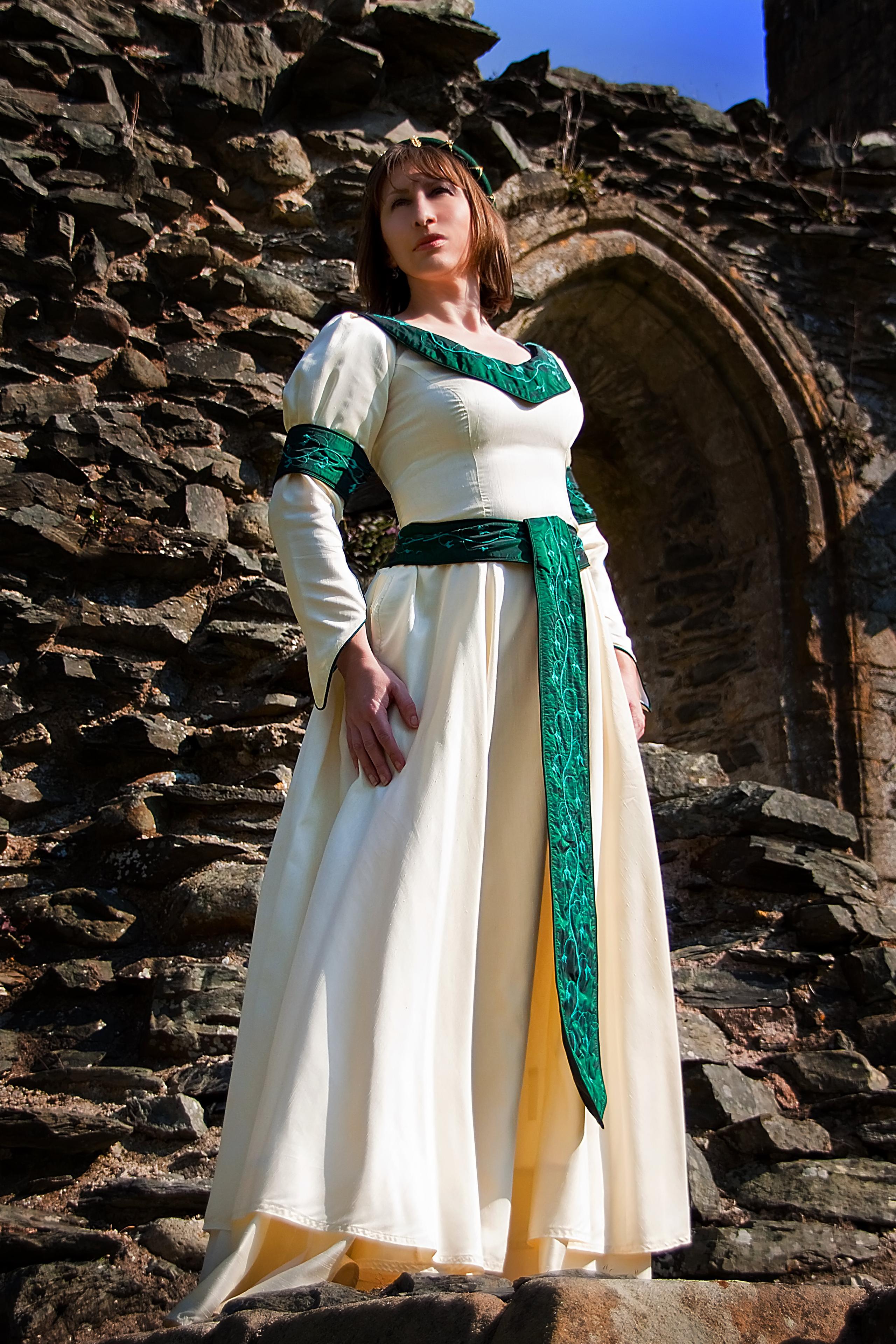 Cream medieval gown to hire with green accents and beading
